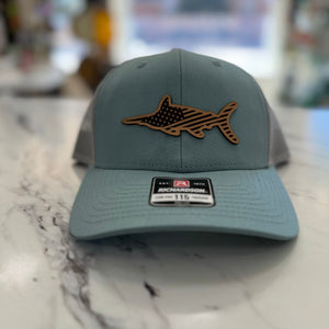 Grey and blue hat with a leather marlin emblem with the USA flag etched into it.