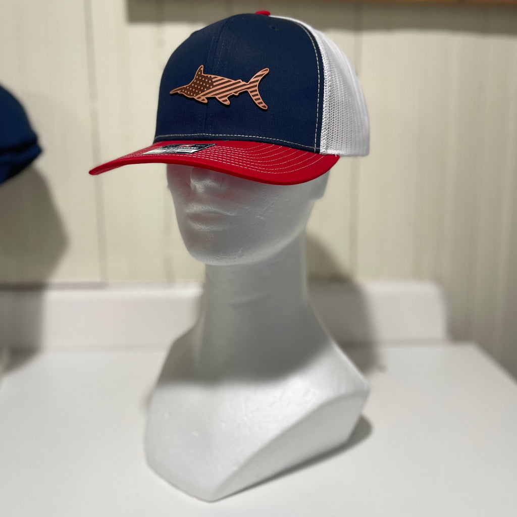 Red, white, and blue hat with a leather marlin emblem with the USA flag etched into it. 