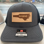 Load image into Gallery viewer, Charcoal grey and black hat with a leather patch that says &quot;Brewed&quot; inside the shape of North Carolina. 
