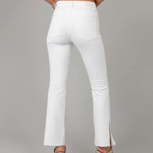 High rise bootcut jeans in a crisp white color with a raw hem and side slit detail at the ankle